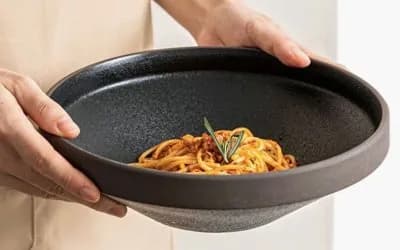 Handmade ceramic bowl used for serving food, highlighting glaze surface and everyday use.